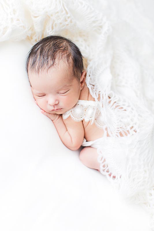 Photographie d'une nouveau-né fille avec dentelle blanche