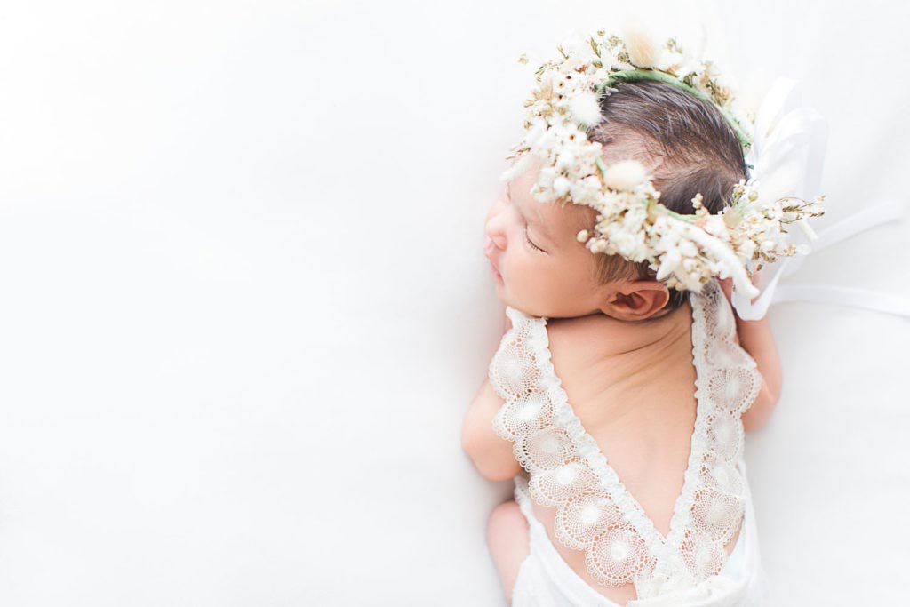 nouveau-né fille avec couronne de fleur