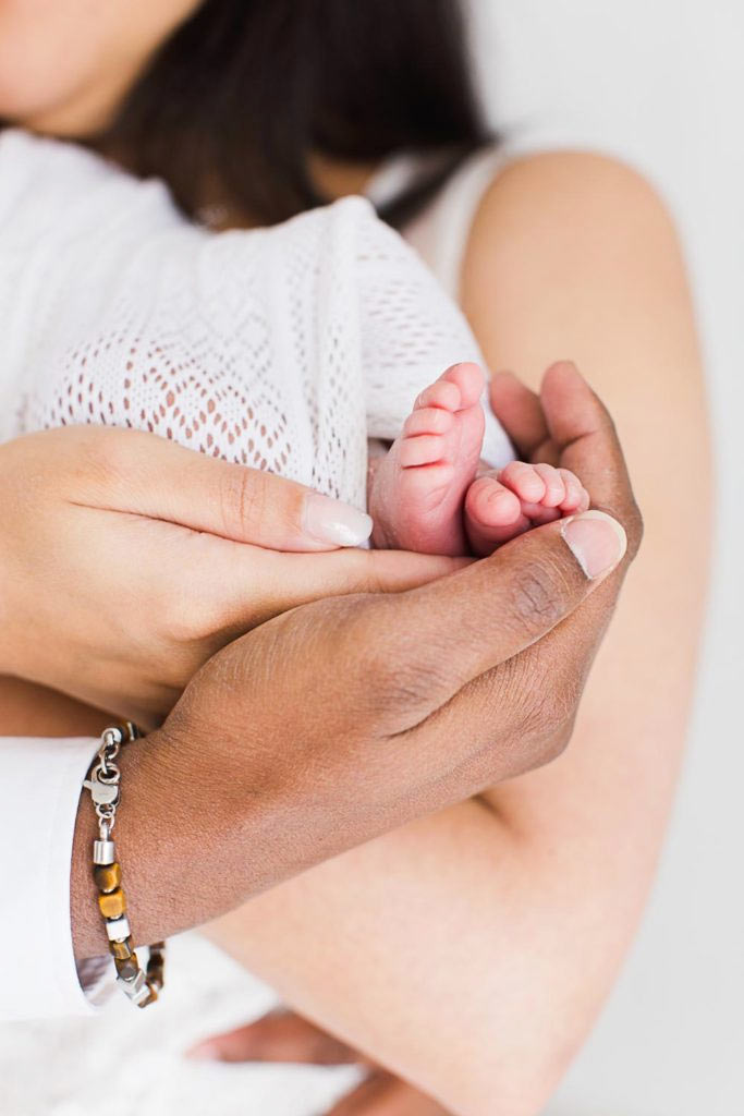 Petit pied de nouveau-né et mains de ses parents