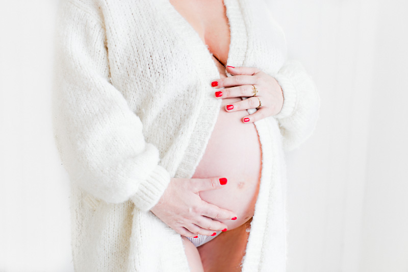 ventre de femme enceinte avec gilet en laine blanc
